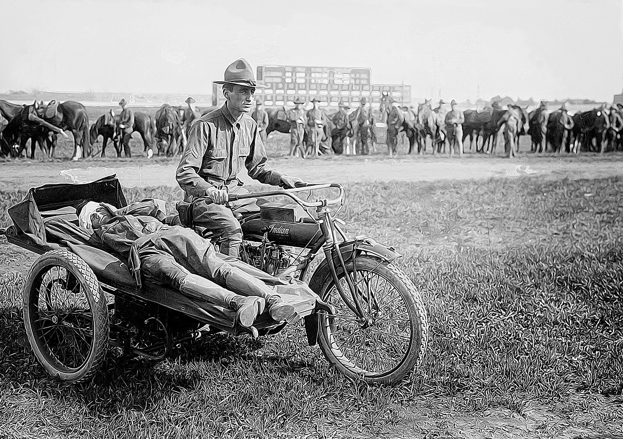 Soldier carrying another injured soldier in sidecar of a bike
