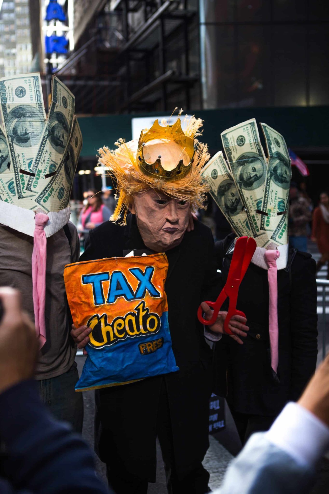 A person in a papier-mâché Donald Trump mask