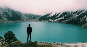 Man standing near lake, looking at horizon