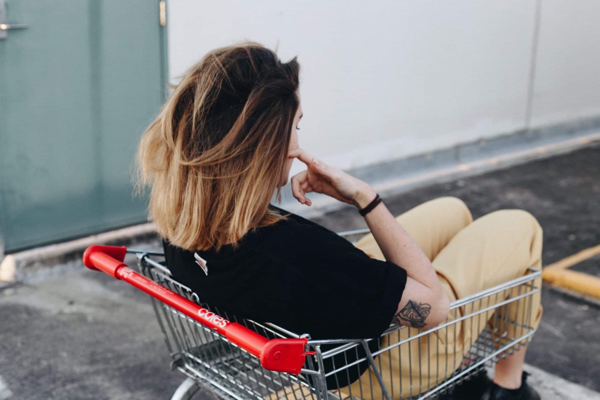 Woman sitting in shopping cart