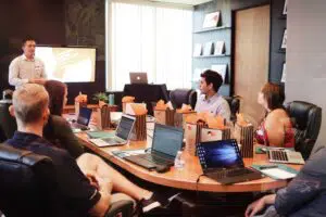 Professionals with laptops sitting in a meeting