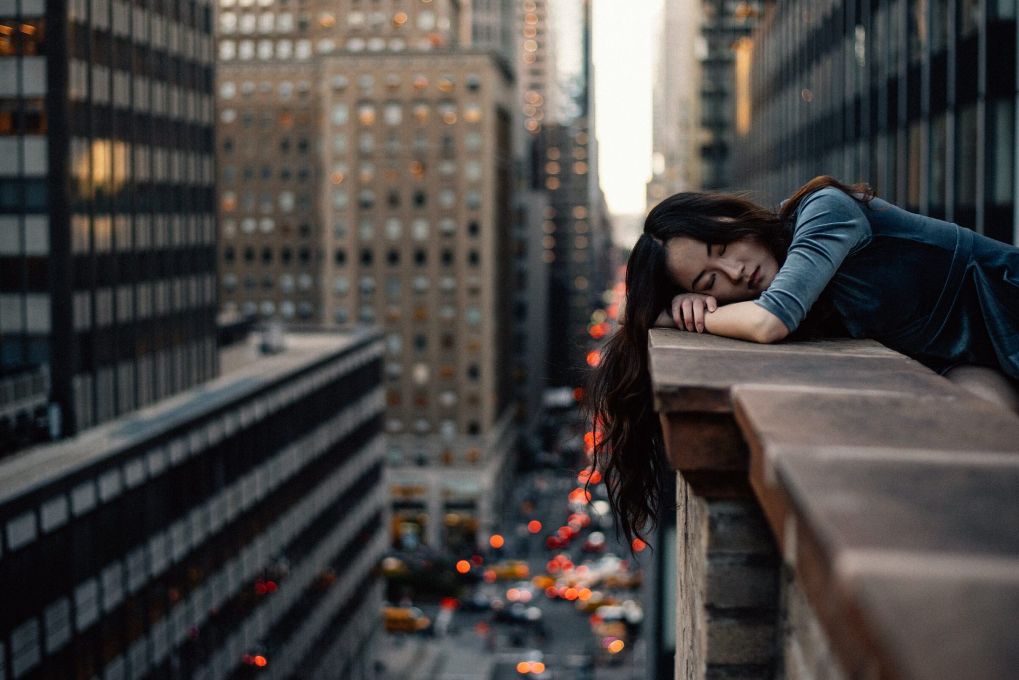 Woman resting head on balcony of skyscraper, sleeping