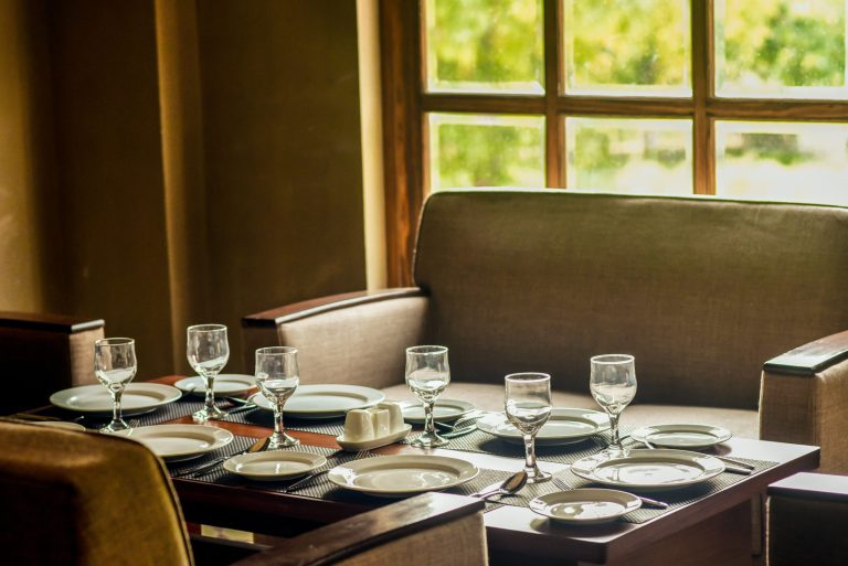 A dining table with glasses of water and plates