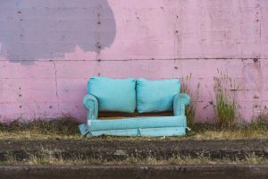 Ragged blue couch placed outdoors