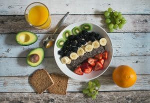 A plate of fruits and vegetables and juice
