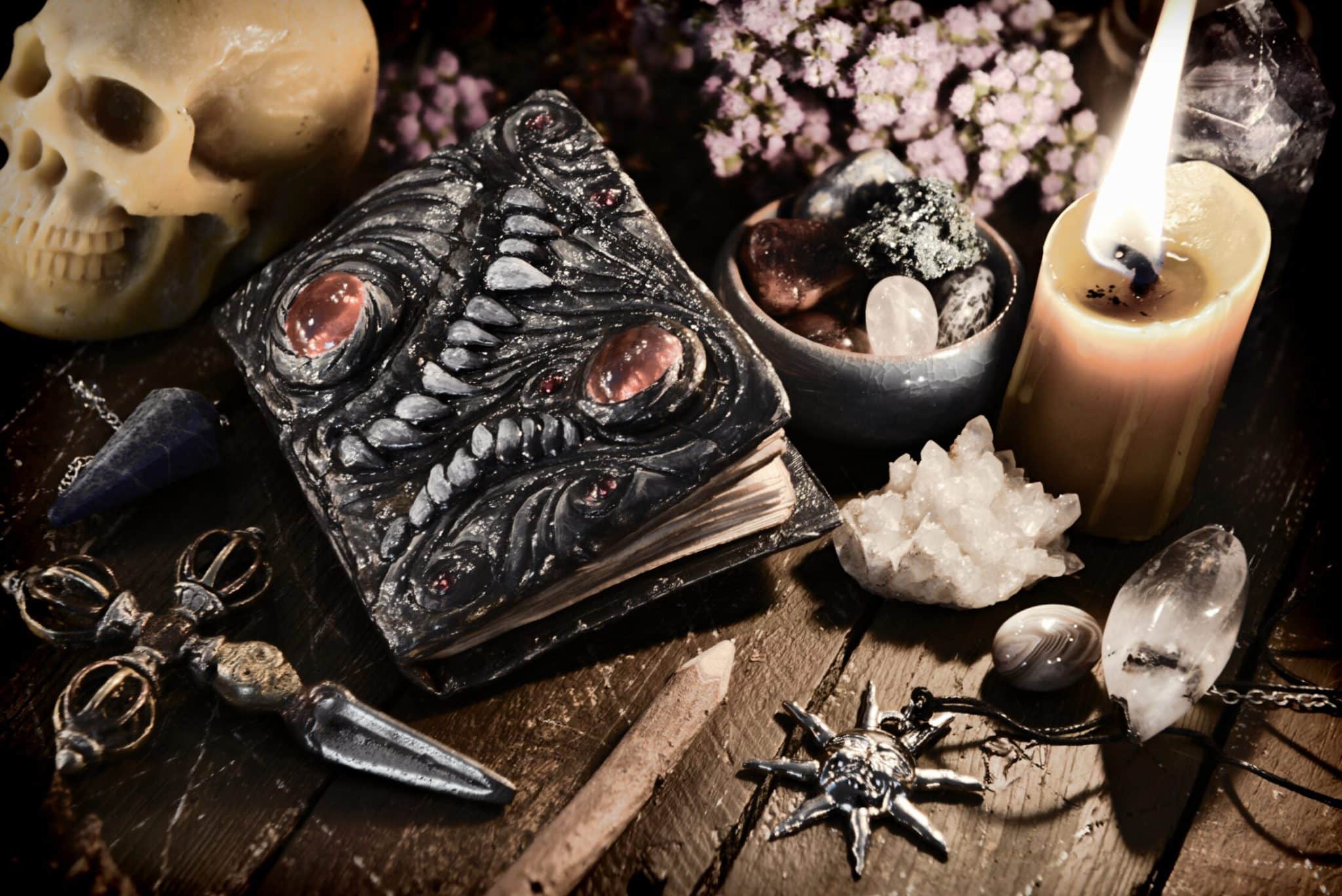 Scary evil book with skull and burning candle. Wicca, esoteric and occult background with vintage magic objects for mystic rituals. Halloween and gothic concept