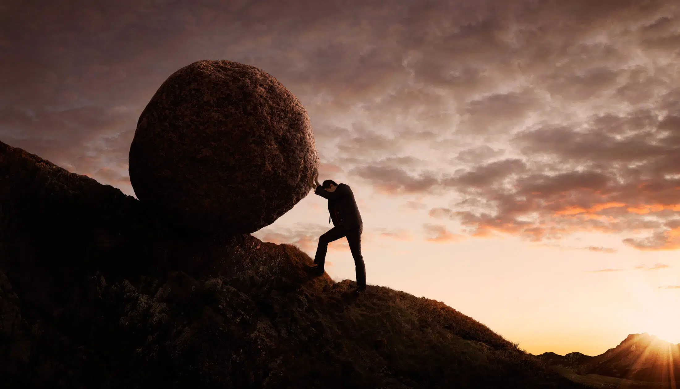 Business concept, Young businessman pushing large stone uphill with copy space