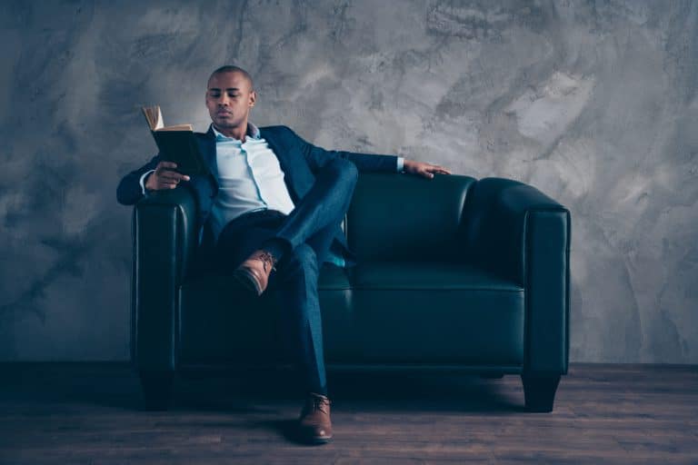 Sexy, Black professional man reading a book on a couch