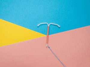 An IUD on a colourful background.